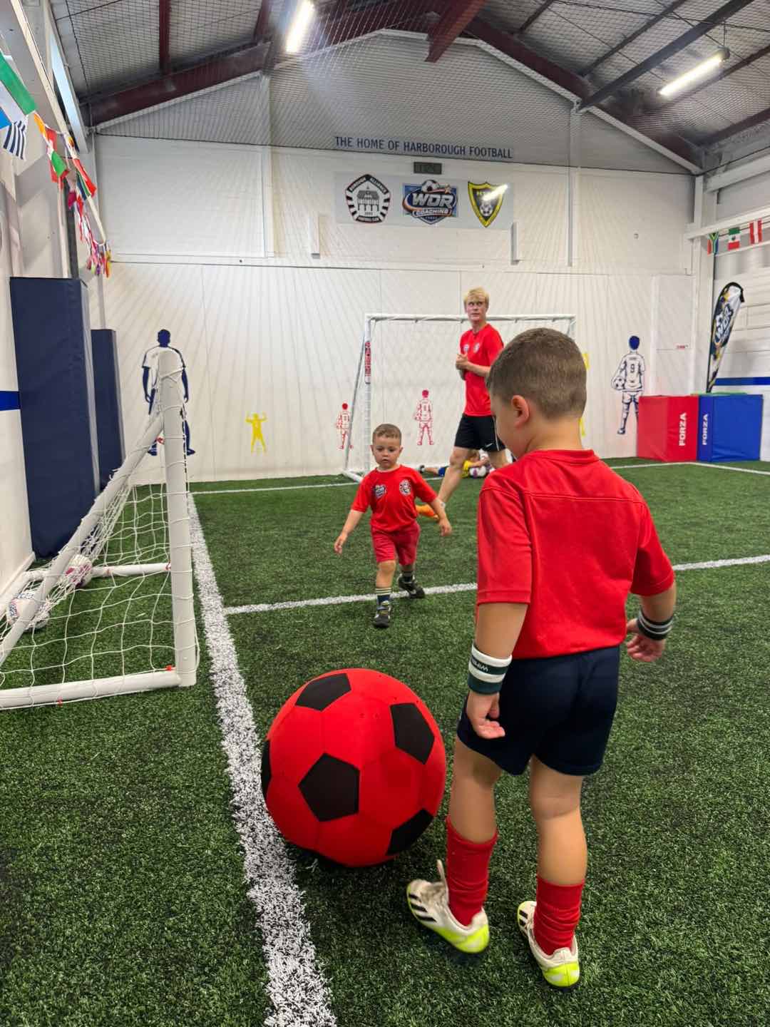 Children playing football on the indoor pitch